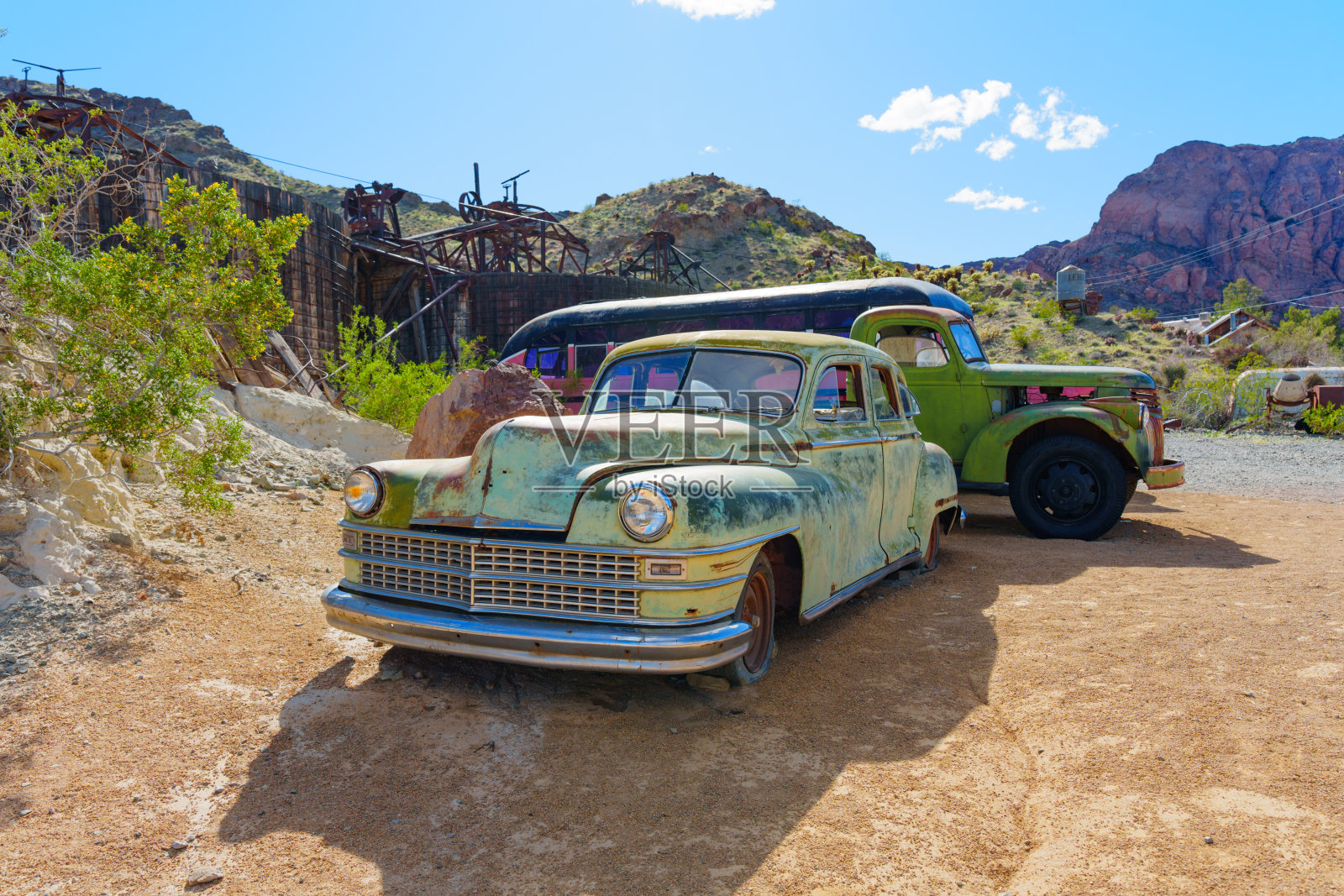 锈迹斑斑的老式汽车停在废弃的金矿建筑前照片摄影图片