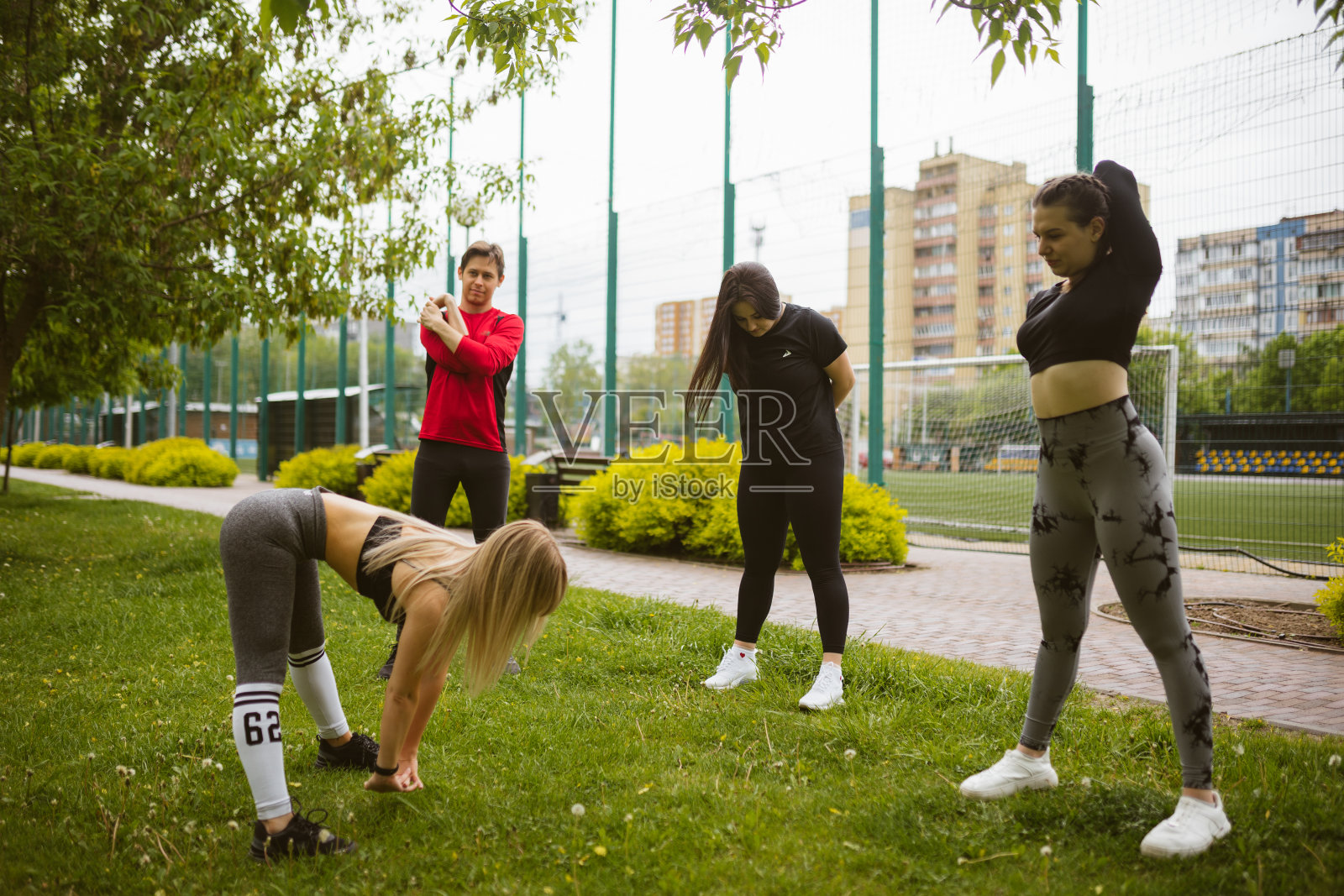 金发教练在运动场展示伸展运动照片摄影图片