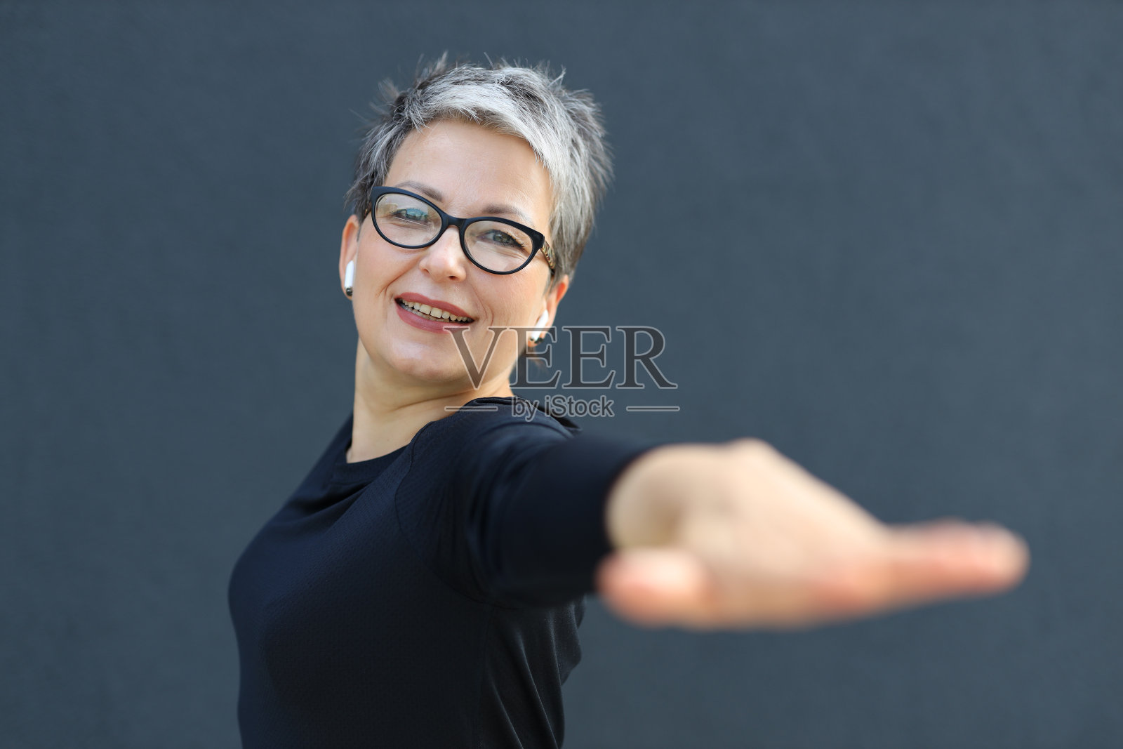 一个快乐、活泼的成熟女人的肖像，带着欢快的微笑，散发着自信和正能量。照片摄影图片