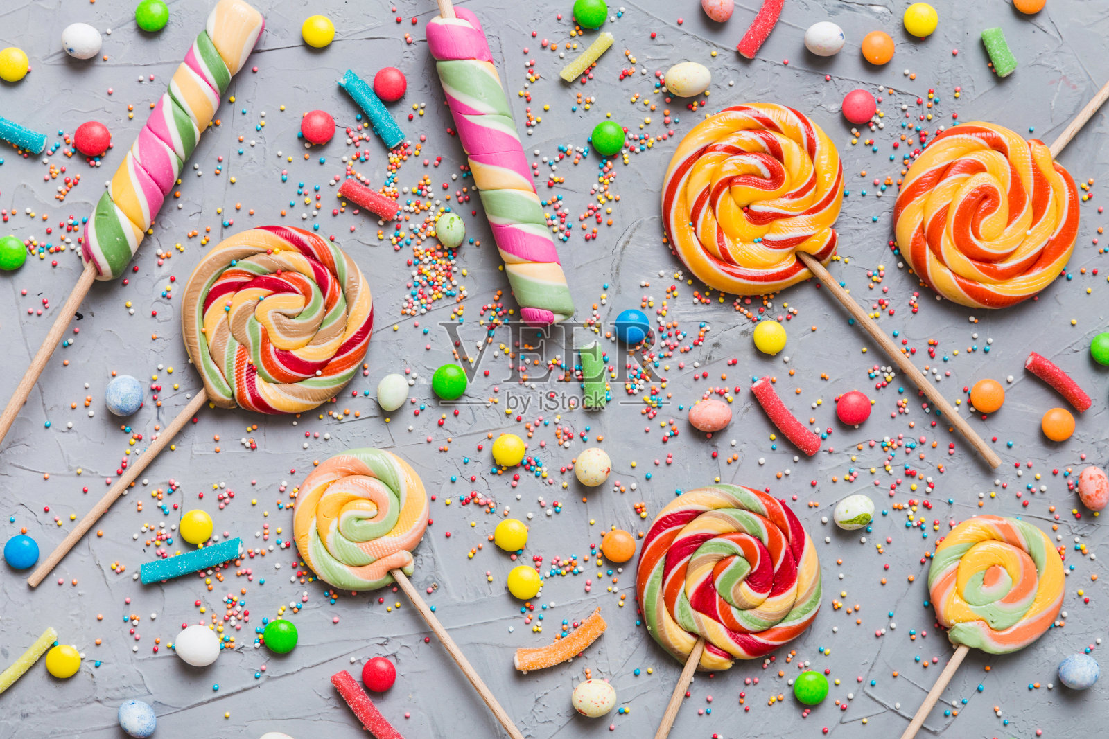 美味开胃的派对配件生日快乐甜蜜。不同类型的糖果在彩色背景上，复制空间。色彩缤纷的生日派对背景照片摄影图片