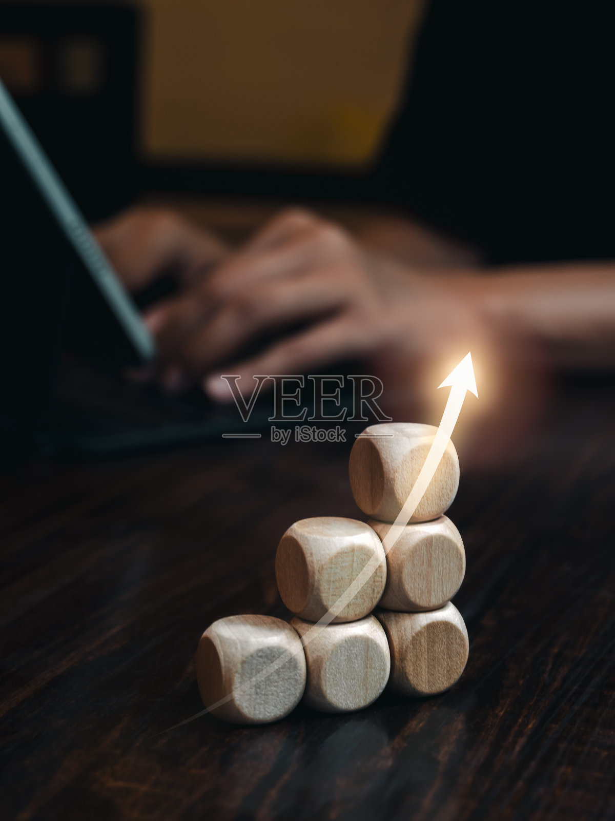 商人用笔记本电脑工作时，办公桌上木棒上的箭头向上上升，柱状图，垂直风格。经营市场增长、努力、利润、投资、财务趋势等理念。照片摄影图片