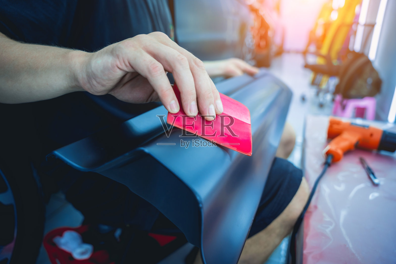 在汽车的细节上安装保护膜的过程。照片摄影图片