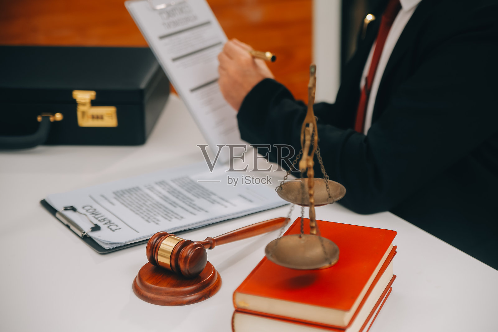 商务人士和律师们在办公室的桌子上用黄铜秤讨论合同文件。法律、法律服务、法律咨询、司法和法律概念图片具有膜纹效果照片摄影图片