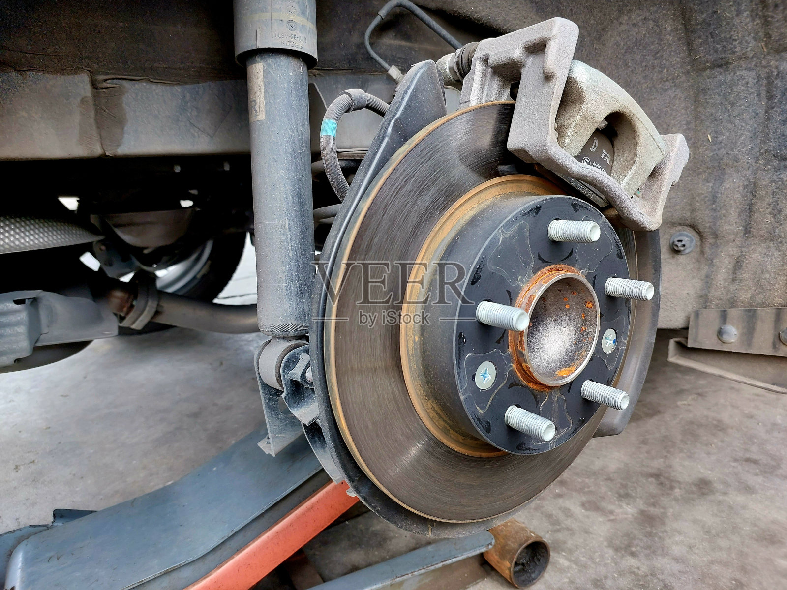 盘式制动器的车辆进行维修，在更换新轮胎的过程中。取下车轮在车库维修，盘式制动器照片摄影图片