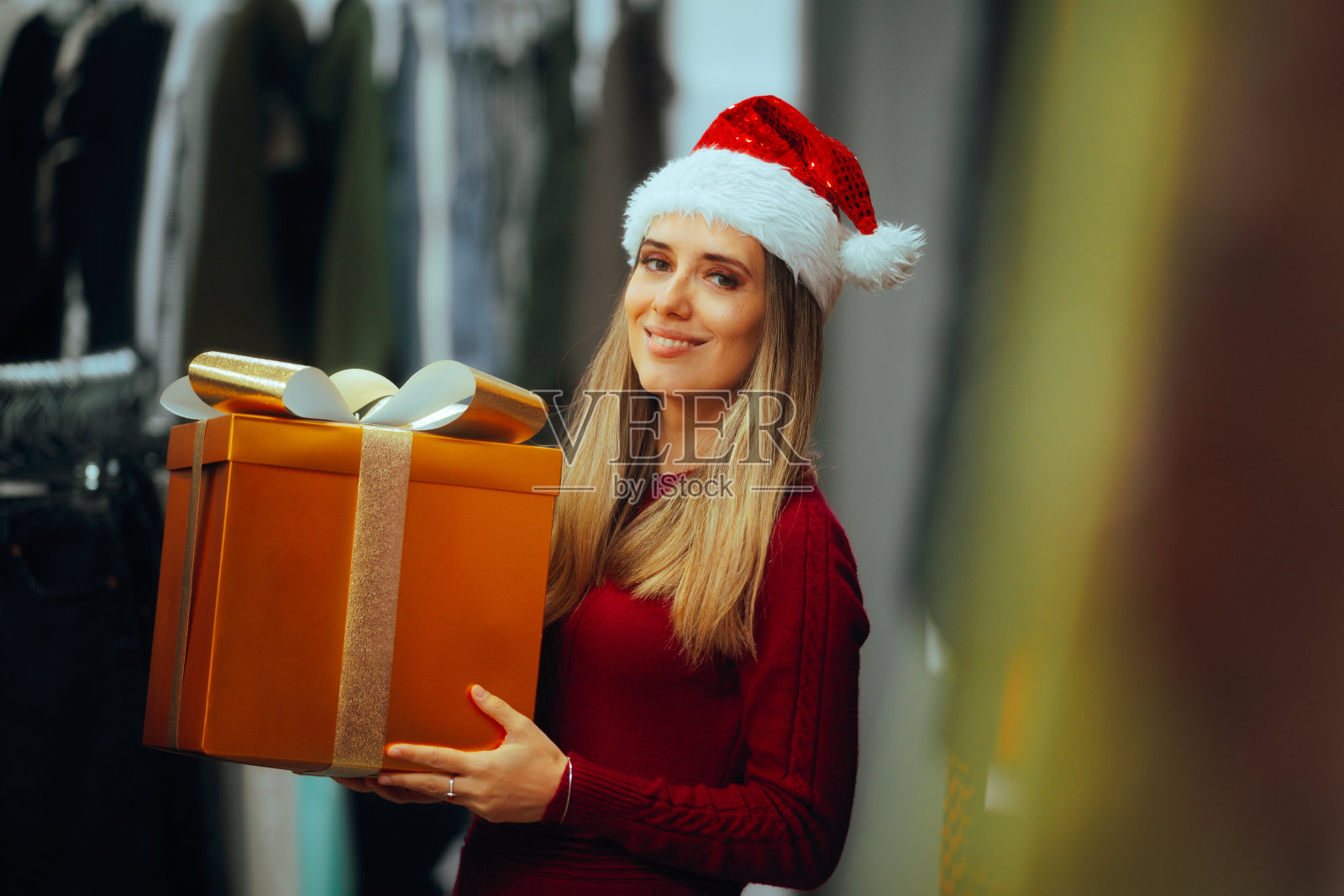 商店里戴着圣诞帽和圣诞礼物的快乐女人照片摄影图片