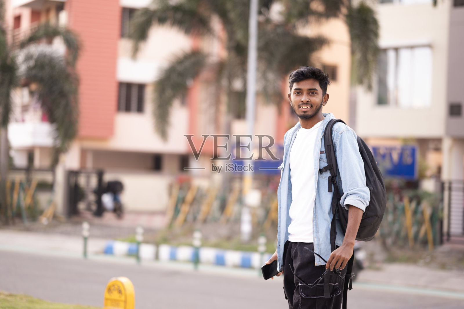 欢快的学生走在城市的人行道上向后看照片摄影图片