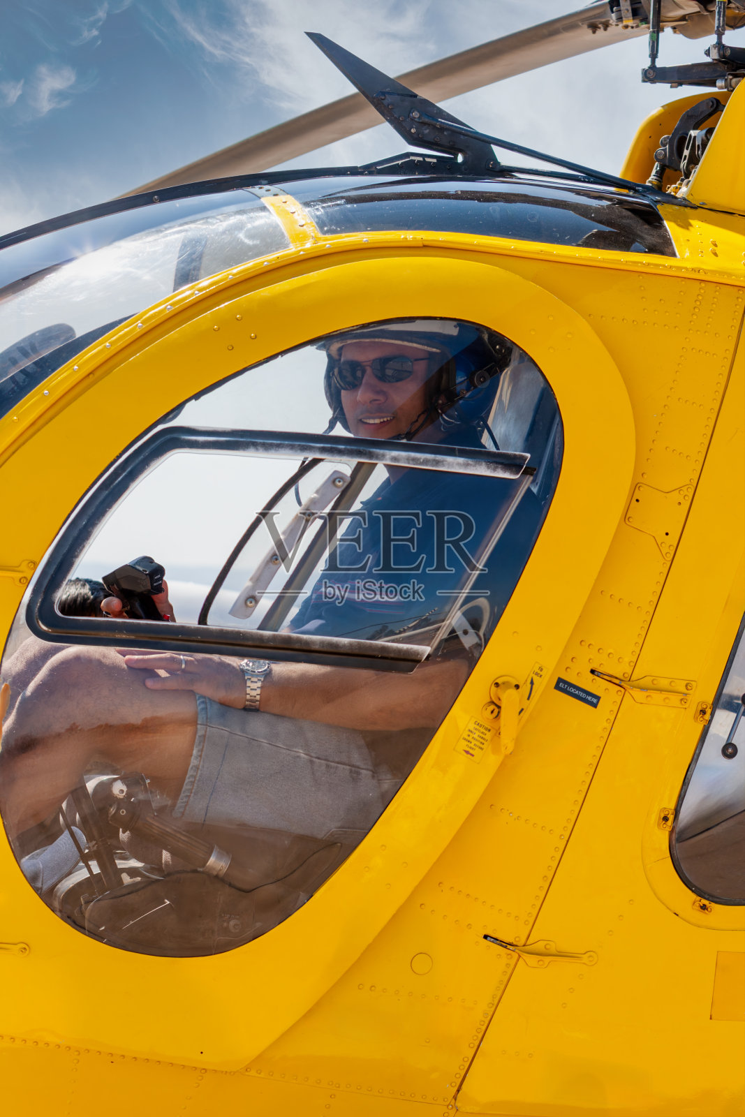 阿拉伯直升机飞行员，驾驶一架救援直升机，戴着头盔和耳机照片摄影图片