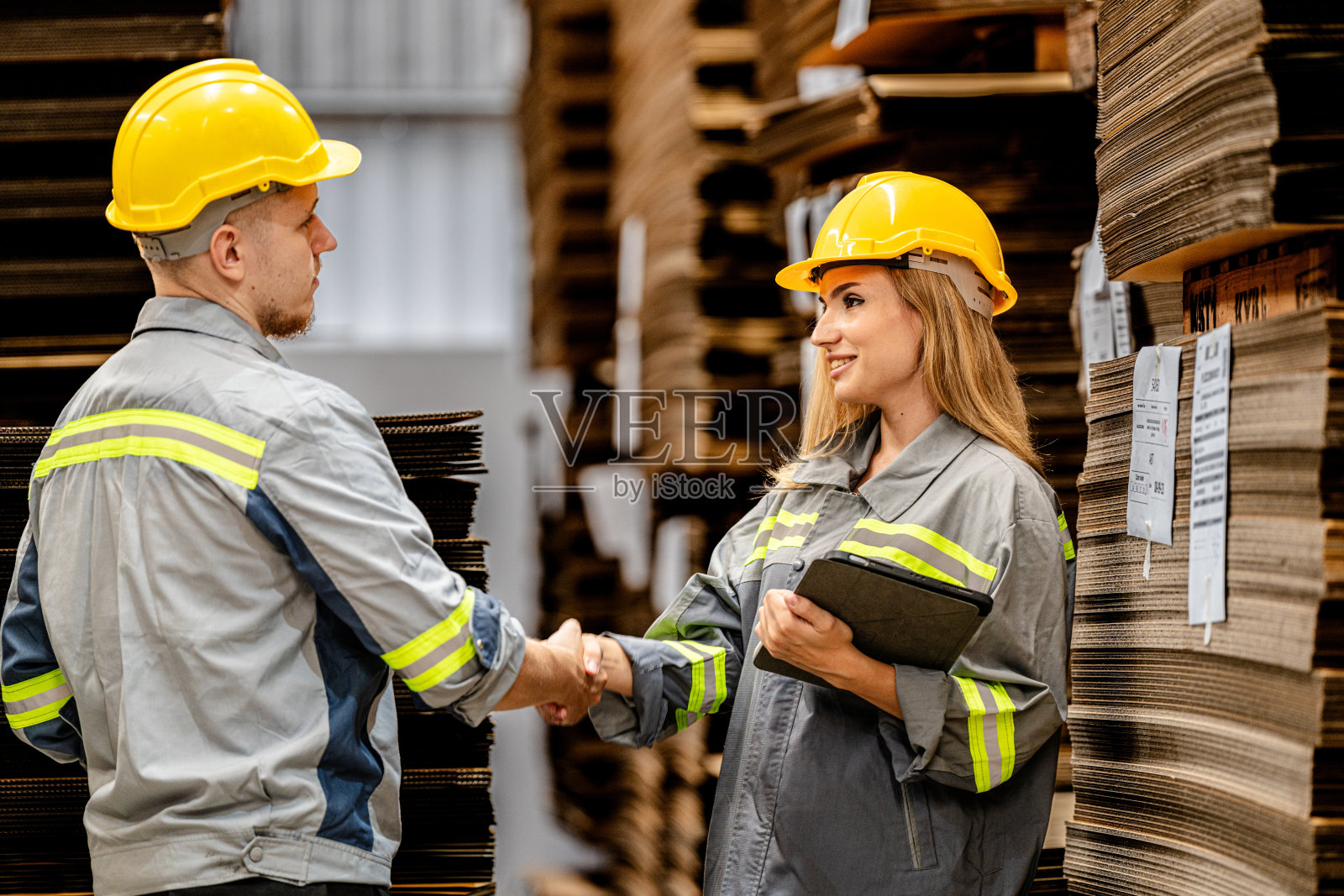 一男一女工人边走边检查货物，准备发货。女工视察商店工厂。物流员工在现场仓库区拿着文件夹准备运输。照片摄影图片