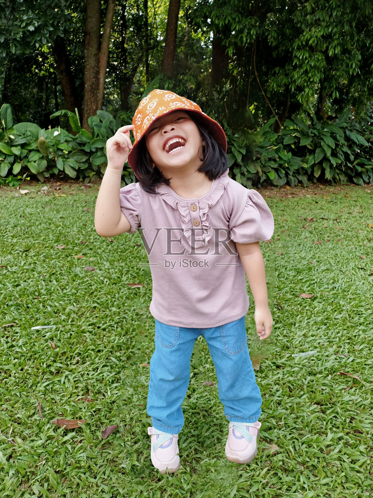 小女孩戴着一顶以花园为背景的富有表现力的帽子照片摄影图片