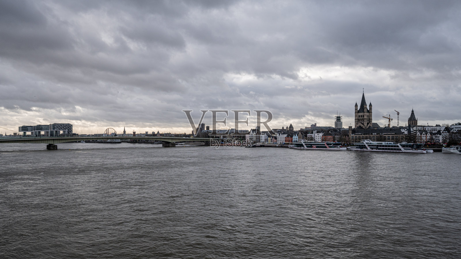 云层在河上盘旋，背景是科隆的城市景观照片摄影图片