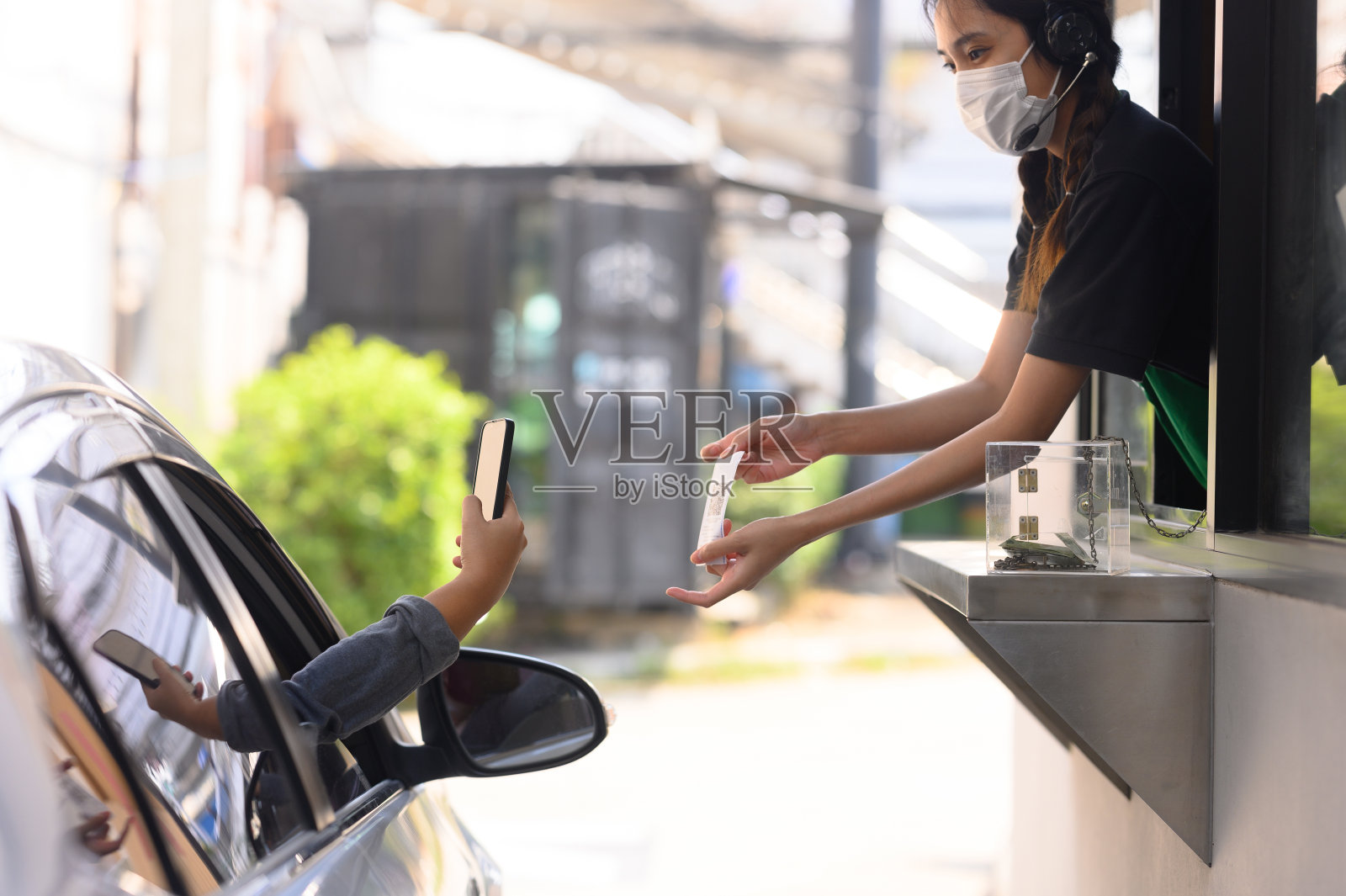 男人们扫描并支付食物，从得来速柜台取食物，带回家或上班时吃。照片摄影图片