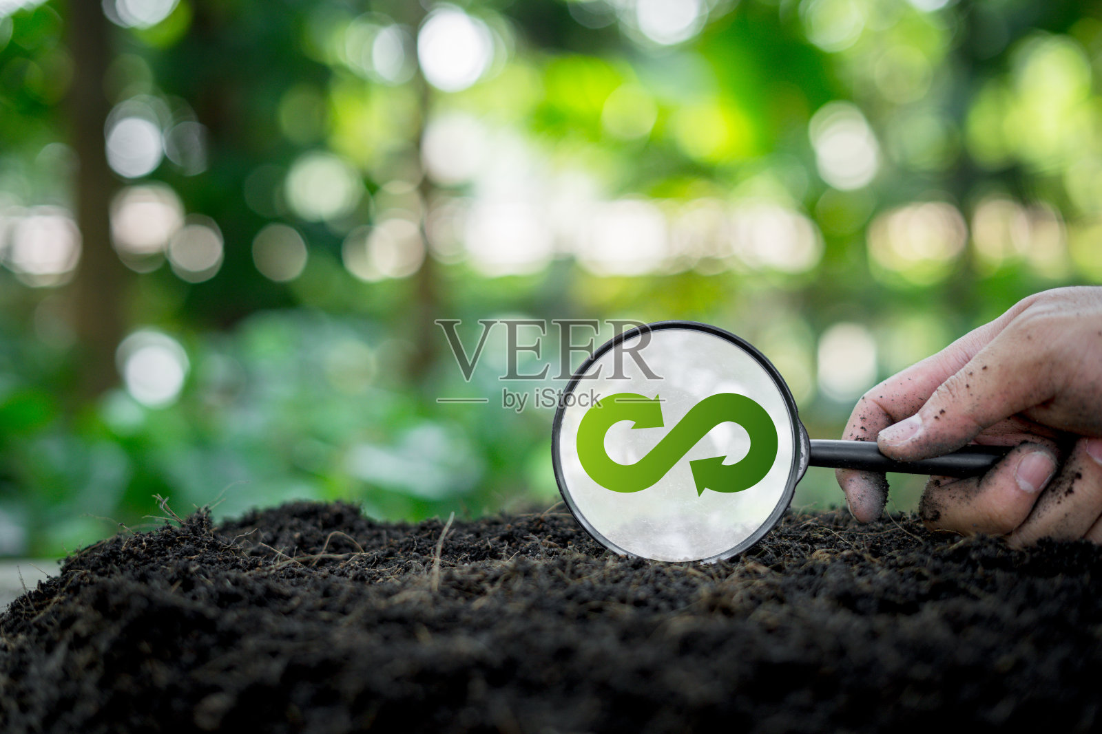 绿色可再生能源有利于未来的增长和环境的可持续性，减少未来的污染，地板上的放大镜带有无穷大的符号照片摄影图片