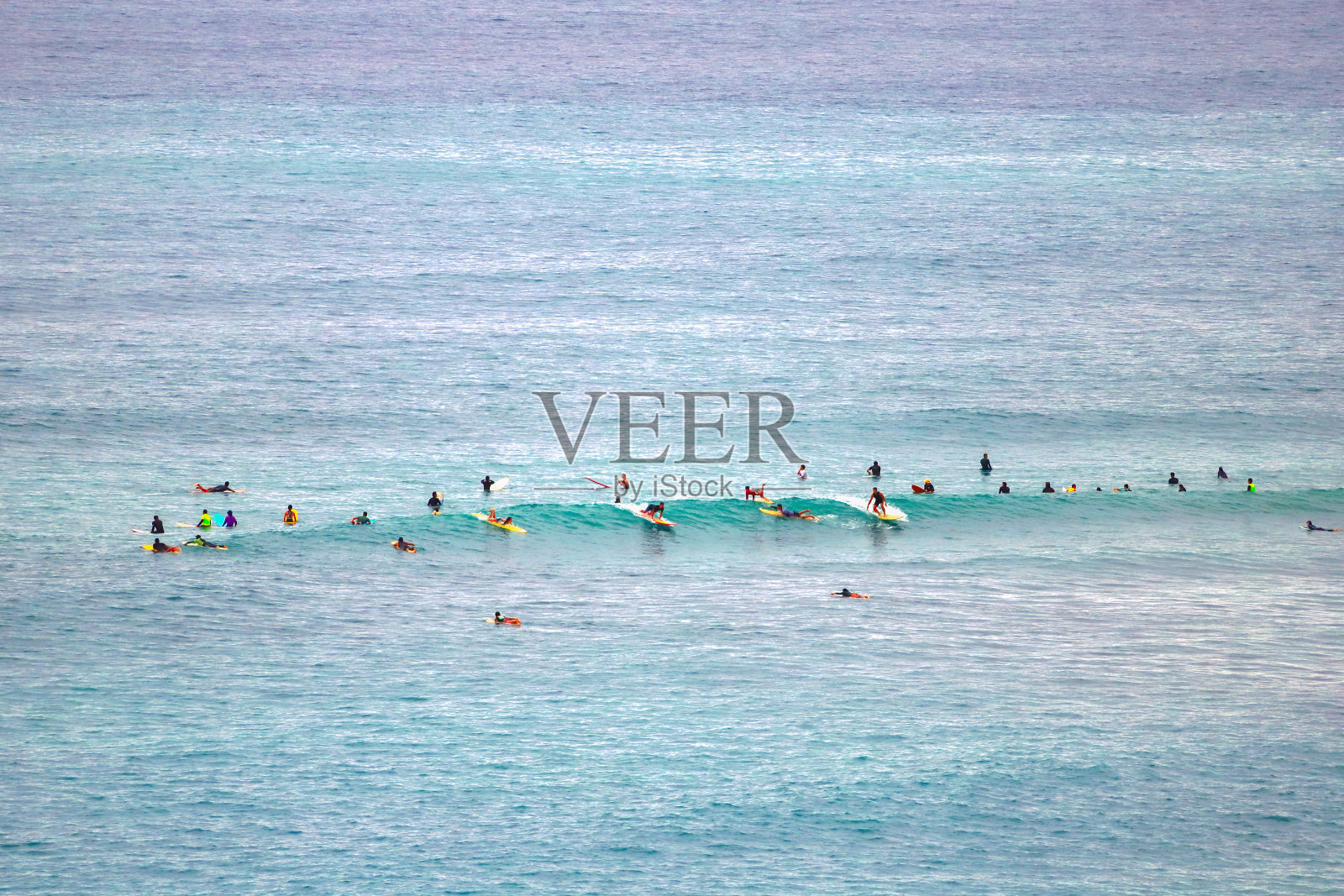 一群热情的冲浪者穿着冲浪服在沙滩上冲浪，遥望照片摄影图片