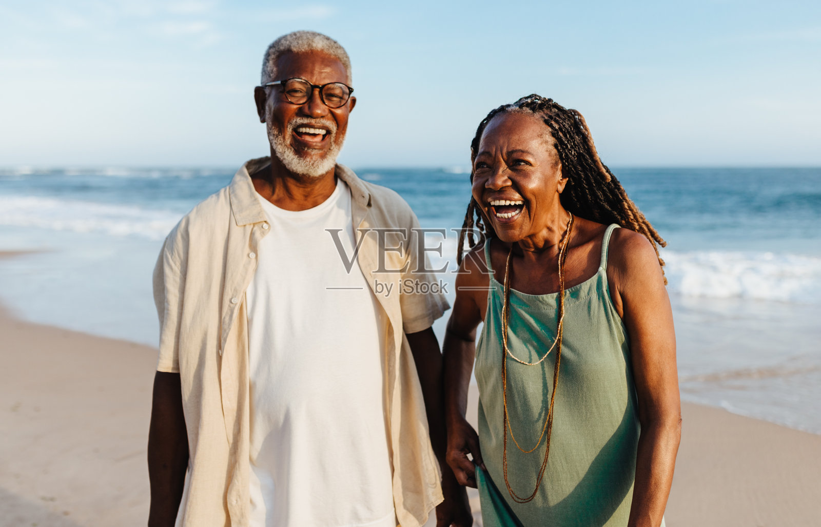 一对快乐的非裔美国老年夫妇在海滩上散步照片摄影图片