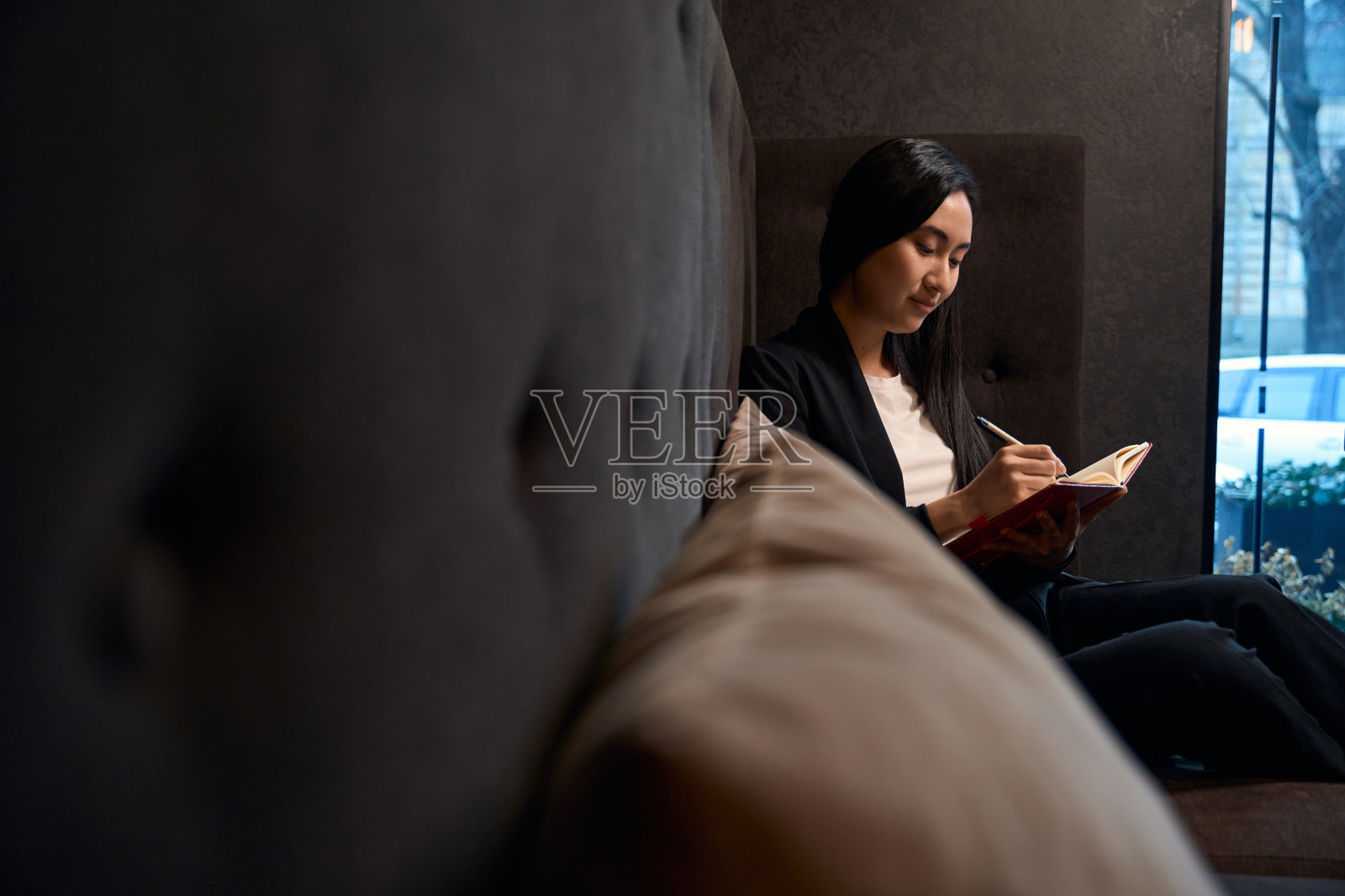 亚洲女人在笔记本上写下她的想法和秘密照片摄影图片