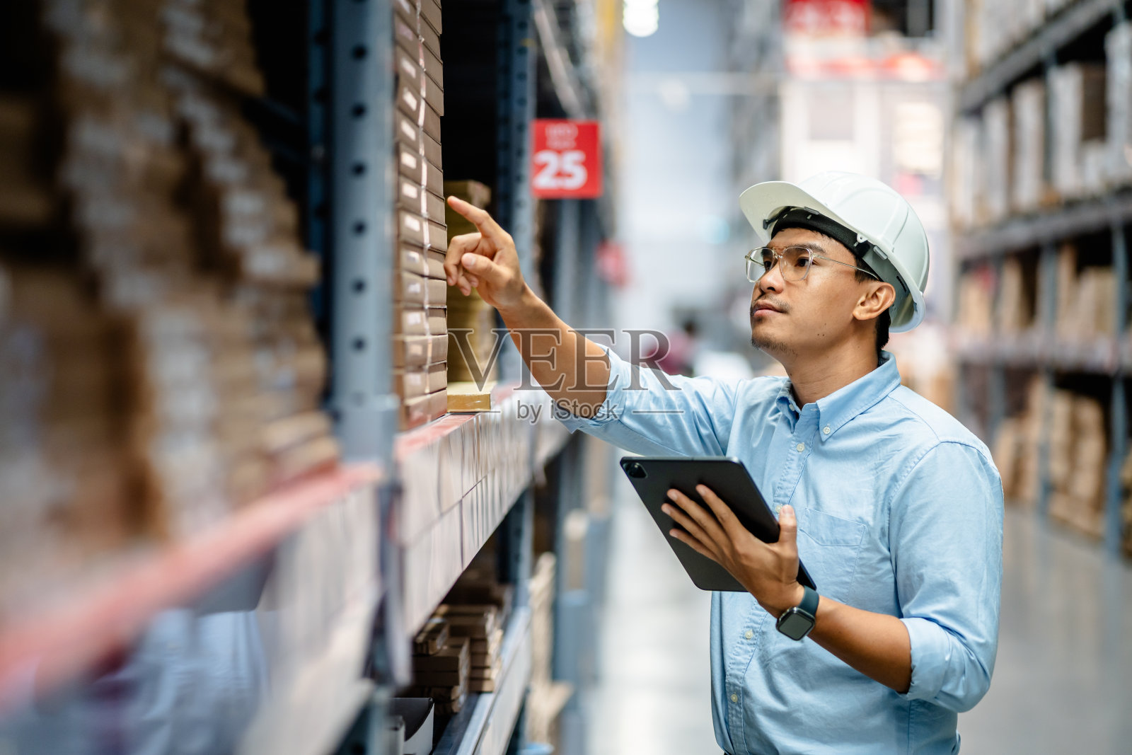 商人或经理使用数字平板电脑查看大型仓库货架上的库存，智能仓库管理系统，供应链和物流网络技术概念。照片摄影图片