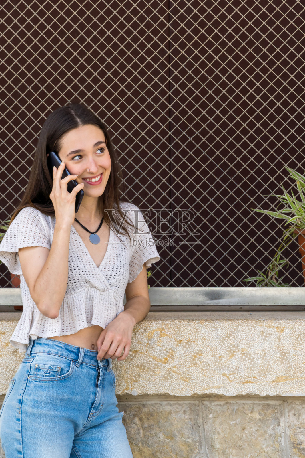年轻的女大学生正在享受她的电话交谈照片摄影图片