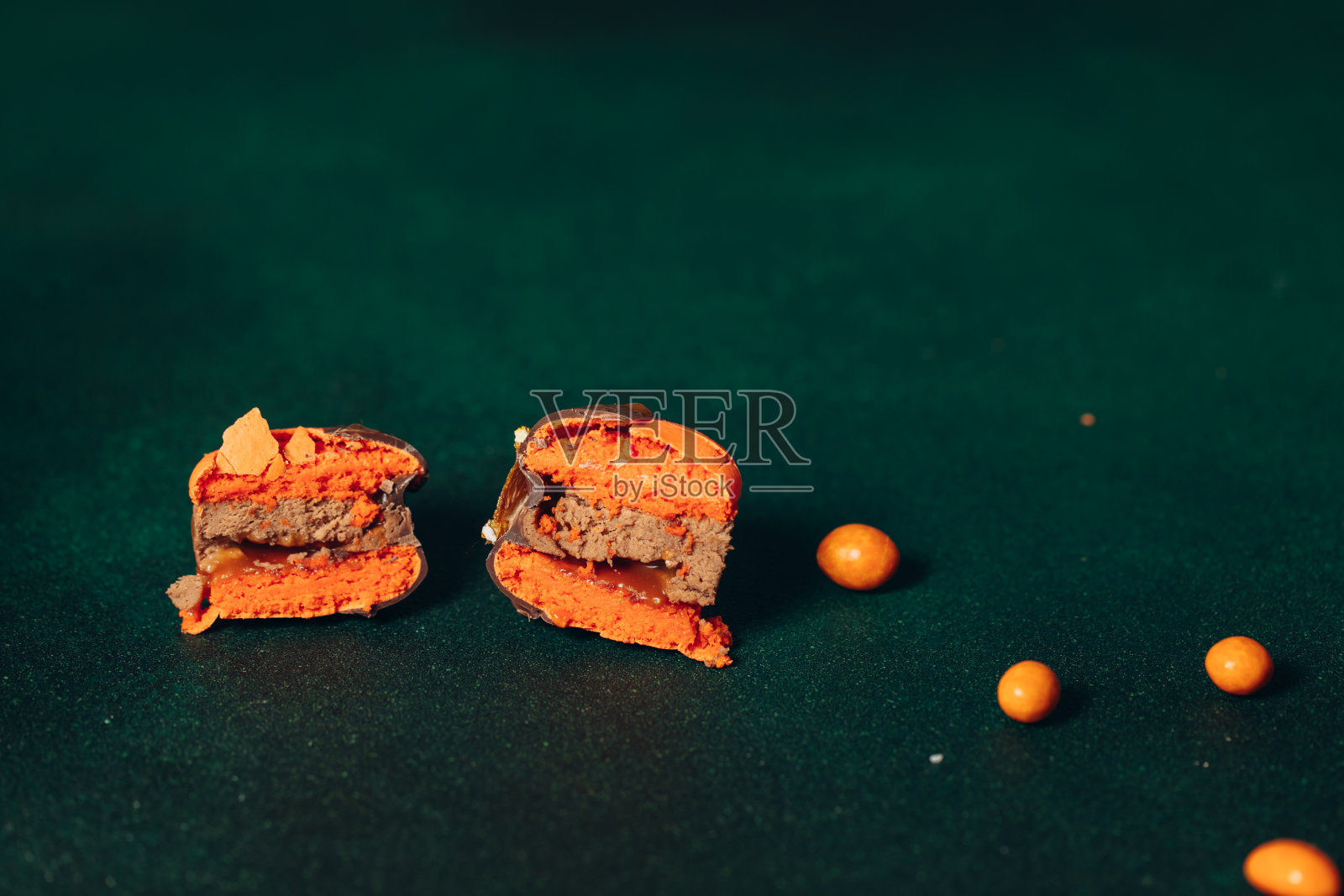 碎甜橙马卡龙，绿色背景照片摄影图片