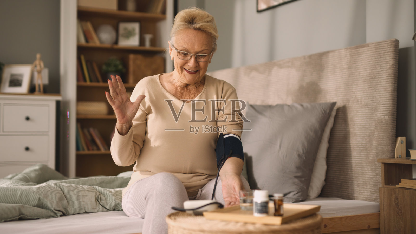 高级女性在卧室测量血压照片摄影图片