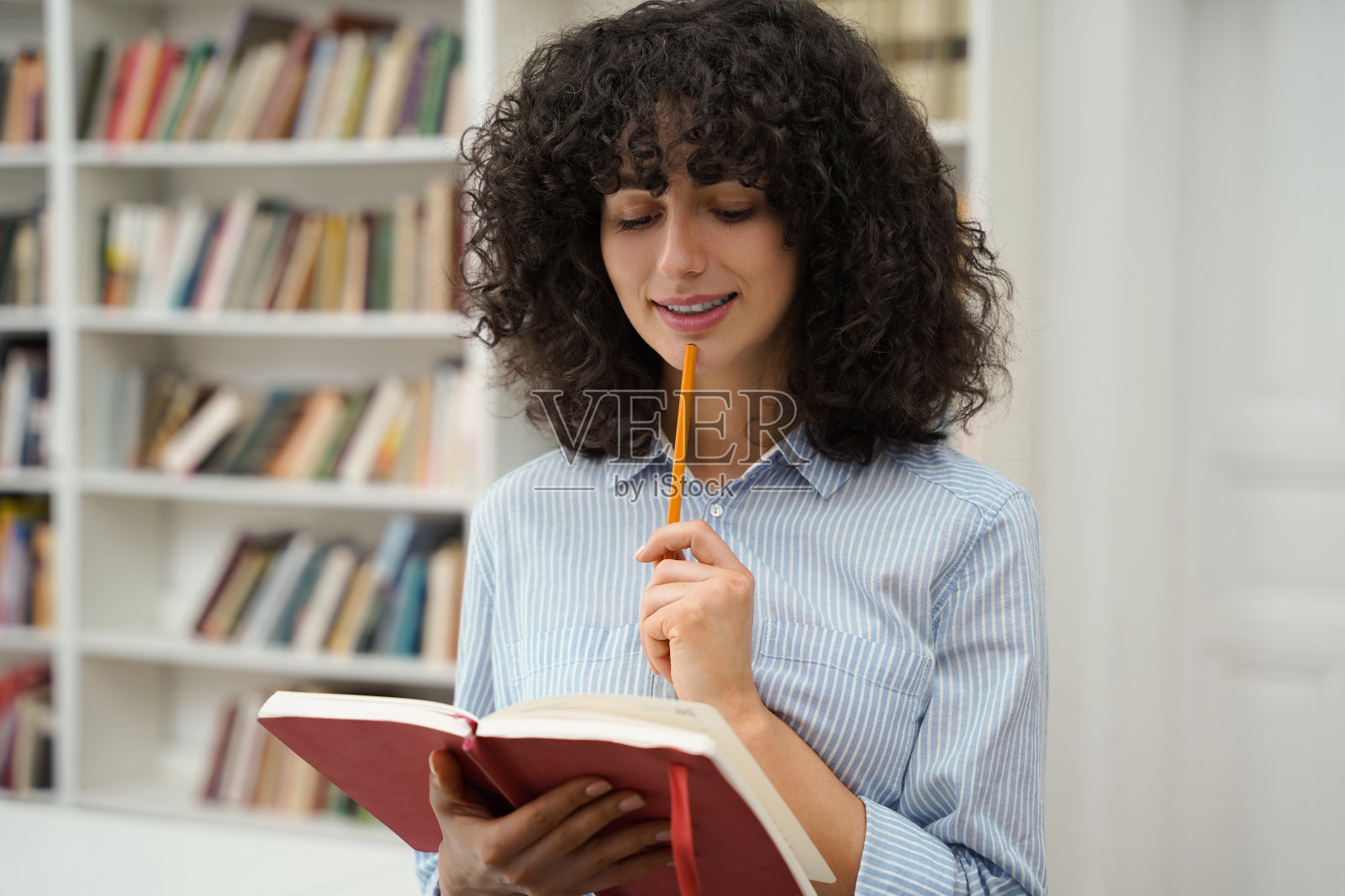 卷发的女学生拿着笔记本学习照片摄影图片