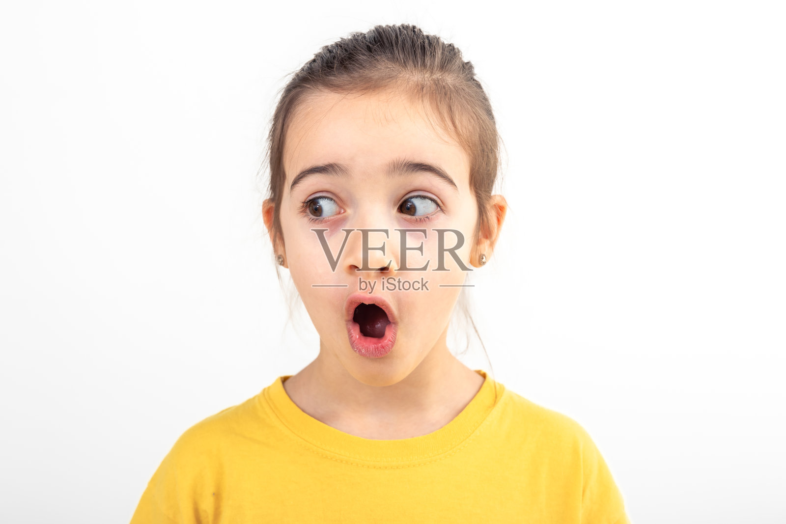 小女孩惊讶地望向一旁，在一个白色的背景孤立。照片摄影图片