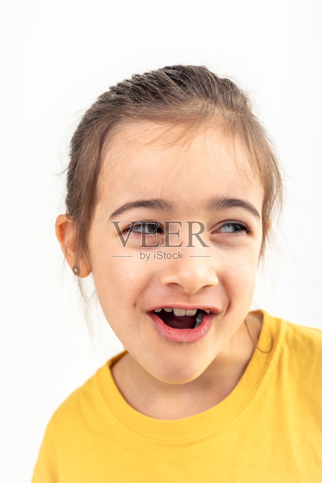 有趣的白人小女孩在白色的背景上孤独地微笑。照片摄影图片