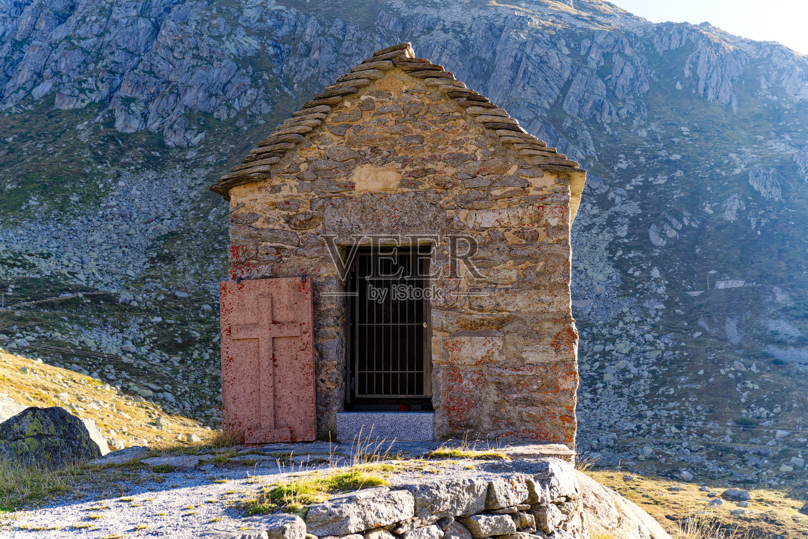 在明亮的阳光下，圣哥达山口的瑞士阿尔卑斯山石雕教堂的美景。照片摄影图片