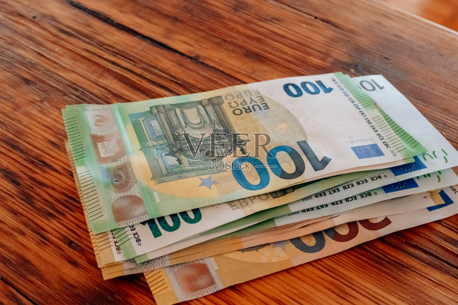 女性手中的欧元钞票。一百欧元钞票。桌上的手在数欧元。欧洲国家妇女的收入。欧盟的钱。欧元区的收入和支出。照片摄影图片