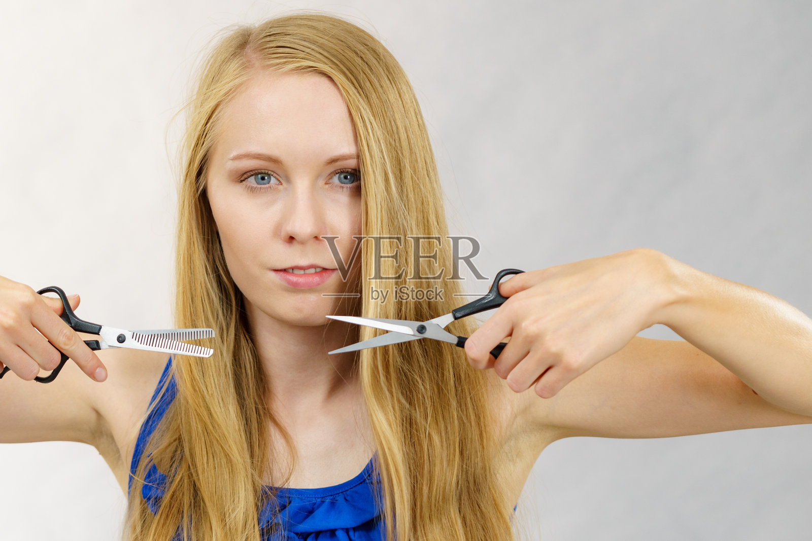 女孩拿着剪刀剪头发照片摄影图片
