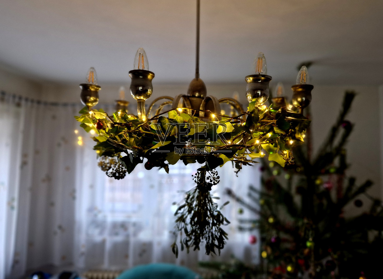 古老的八臂吊灯。银色单株，云杉锥形球茎，底部有一个球。有窗帘的白色房间。底部视图。烛台形状，蜘蛛，包裹，降临，铬照片摄影图片