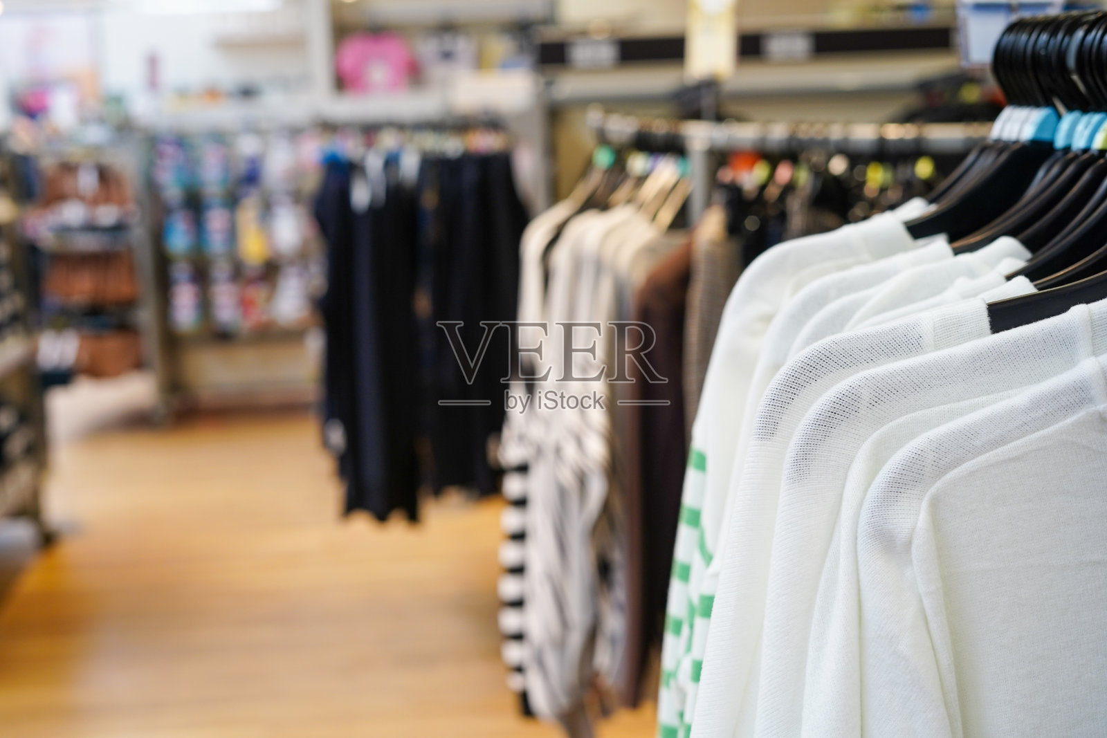 大商场里时髦的衣服挂在衣架上照片摄影图片