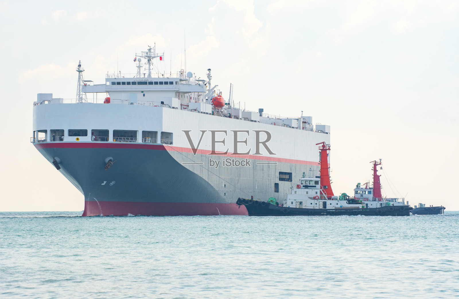 满载货物的货船、汽车运输船用拖船接近港口，占用港口的国际集装箱船在海港装卸，货物运输、船运、船舶。物流，进出口，运输。全球反式照片摄影图片