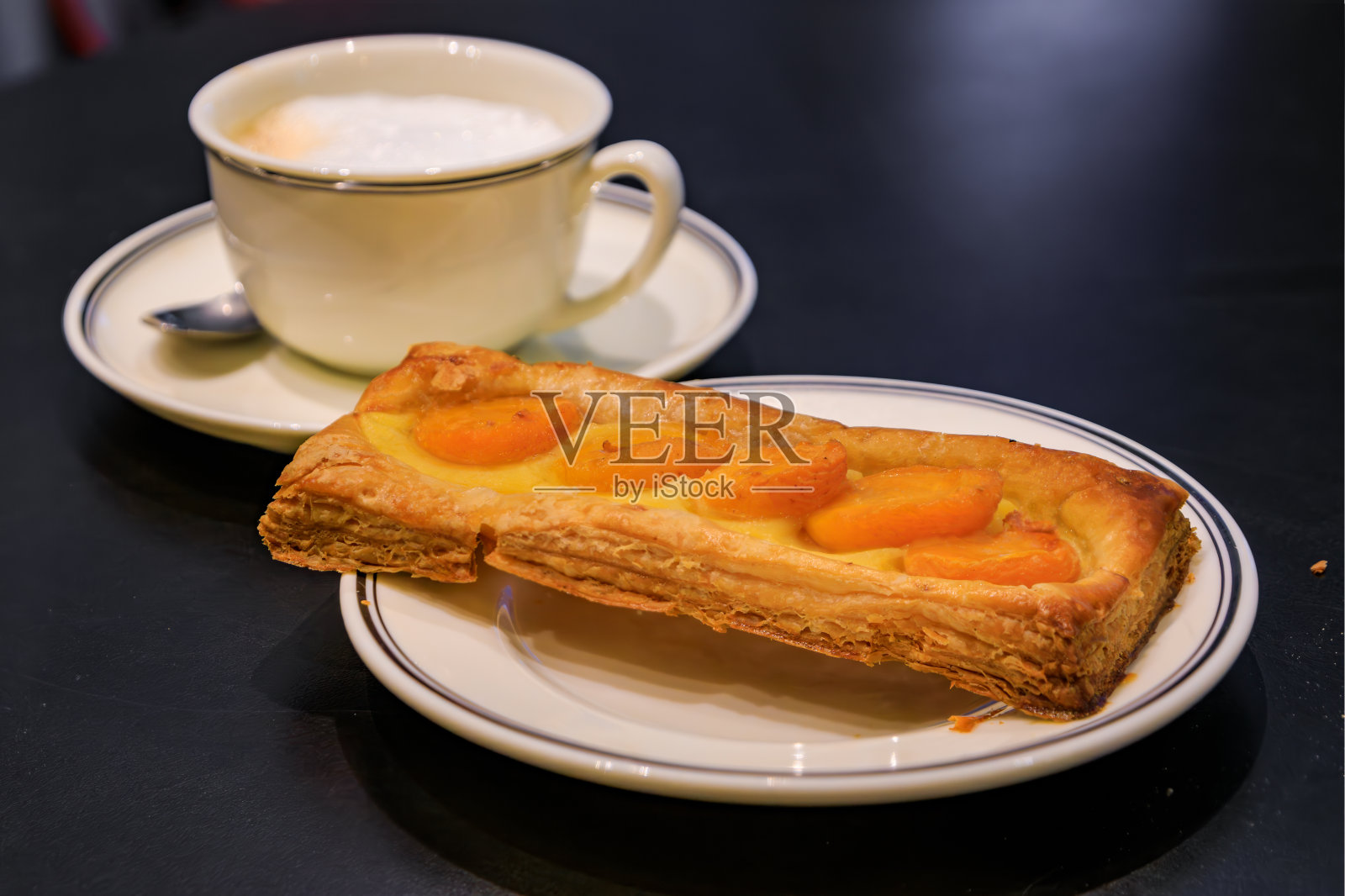 在法国斯特拉斯堡的一家面包店，糕点或杏馅饼和一杯咖啡照片摄影图片