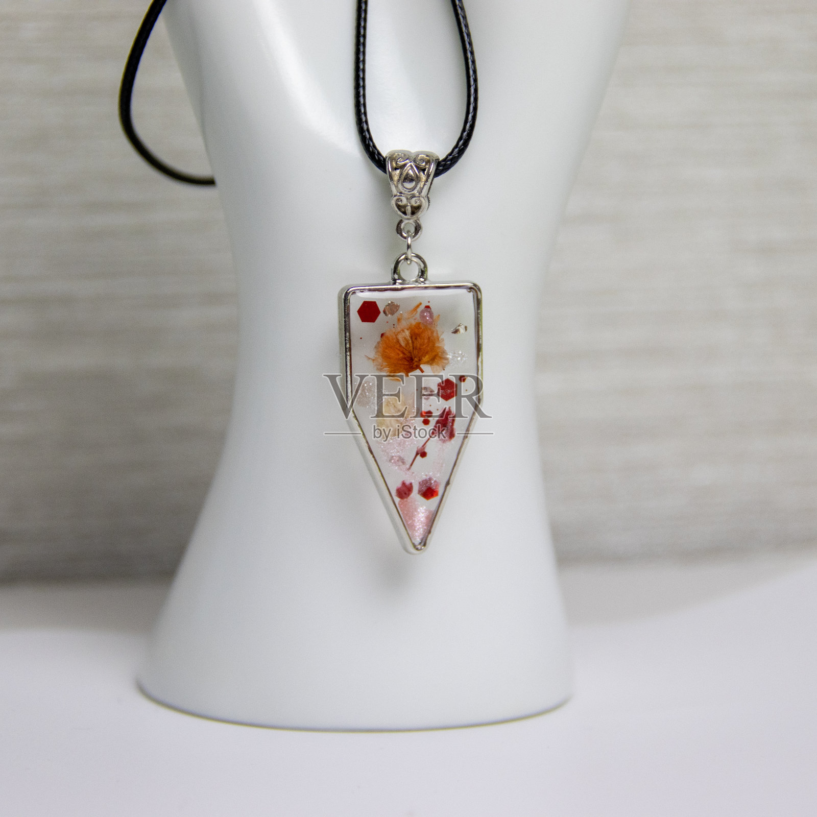 用环氧树脂和天然花朵制作的DIY服装首饰，DIY首饰大师。美丽的耳环和吊坠在家里制作的珠宝树脂。照片摄影图片