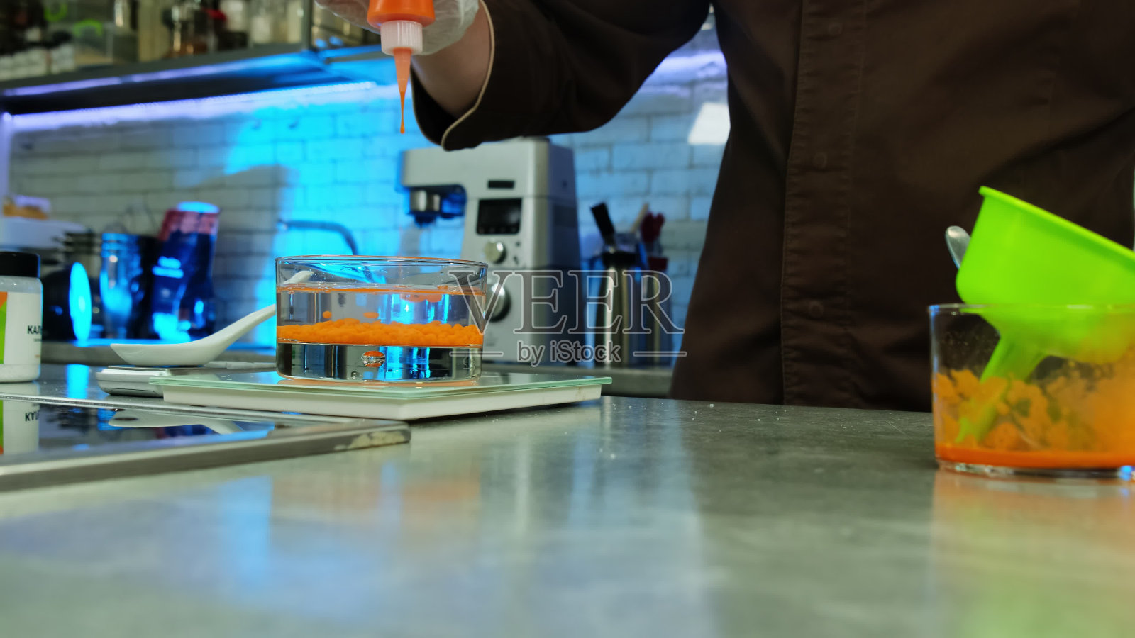 库克将有色液体与冷植物油一起滴在玻璃中照片摄影图片