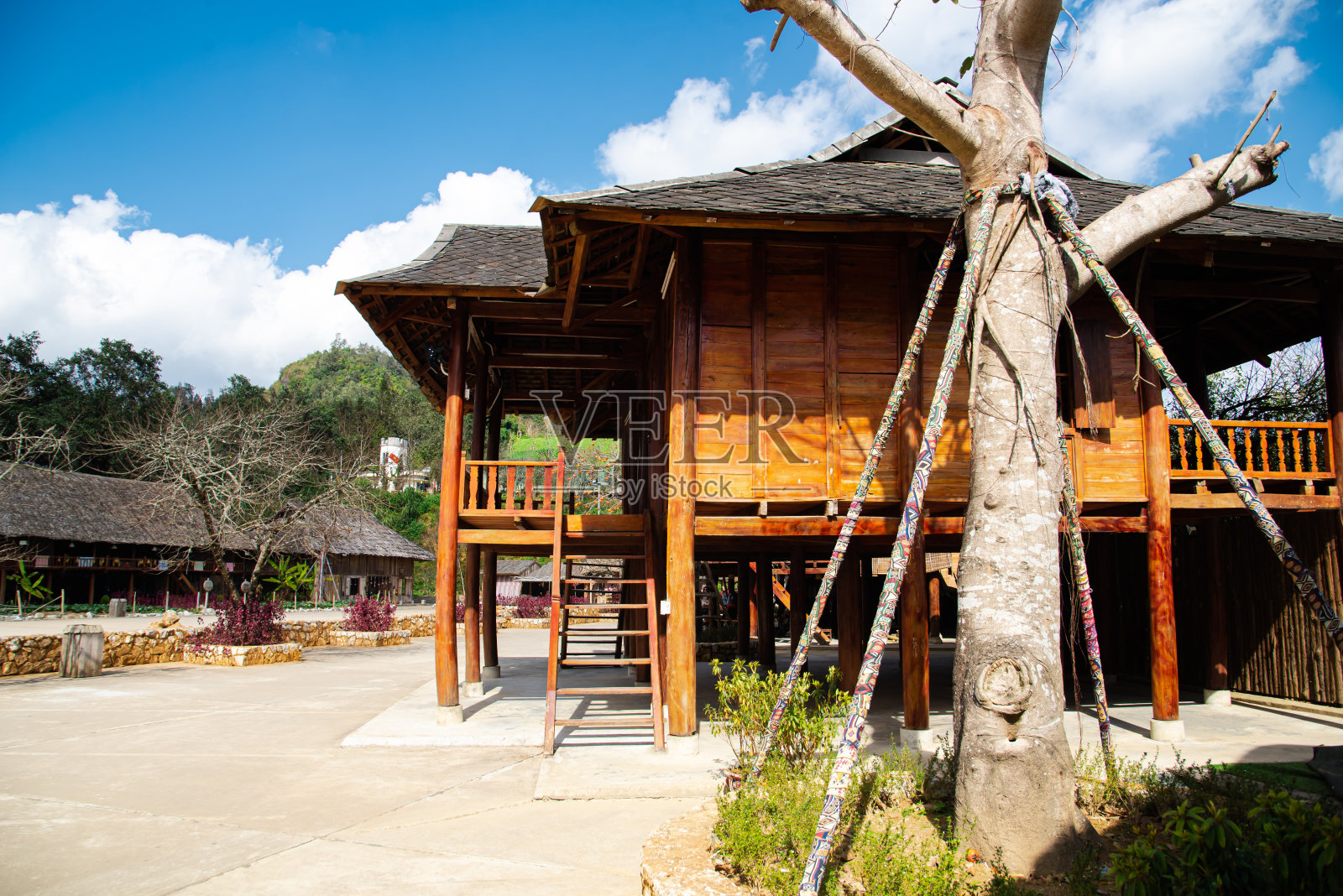 越南西北高山旅游村的少数民族茅草屋顶木桩房屋模型，是越南偏远地区农村生活的强烈象征照片摄影图片