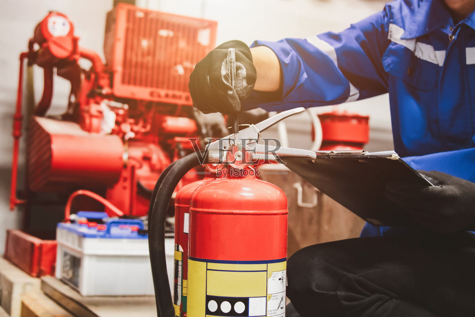 工程师检查灭火系统，检查消防控制室的灭火器罐是否安全照片摄影图片