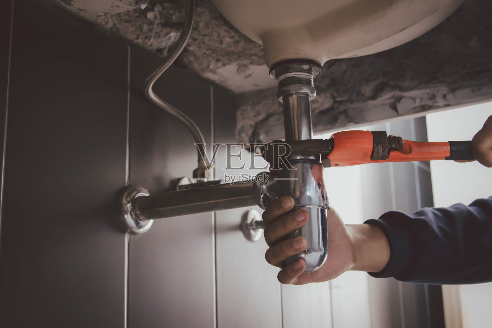 在浴室工作的水管工，管道维修服务，修理水管道泄漏，更换厨房水槽排水管照片摄影图片