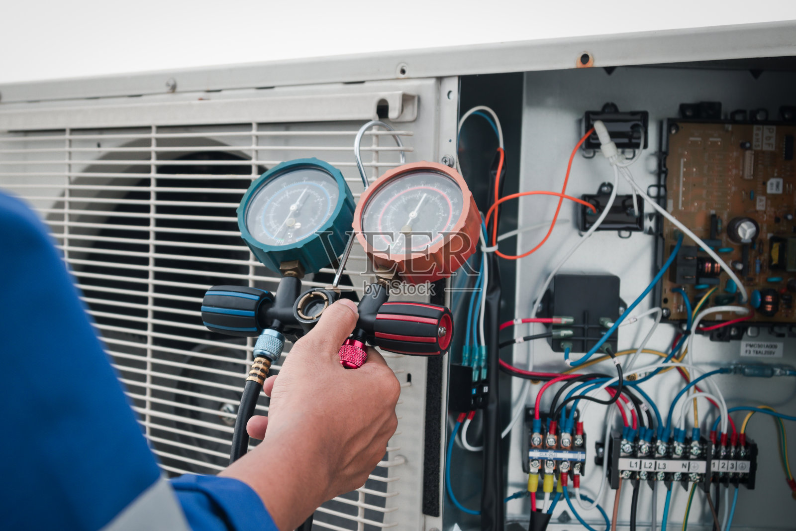 技术员正在检查空调，测量空调填充设备。照片摄影图片