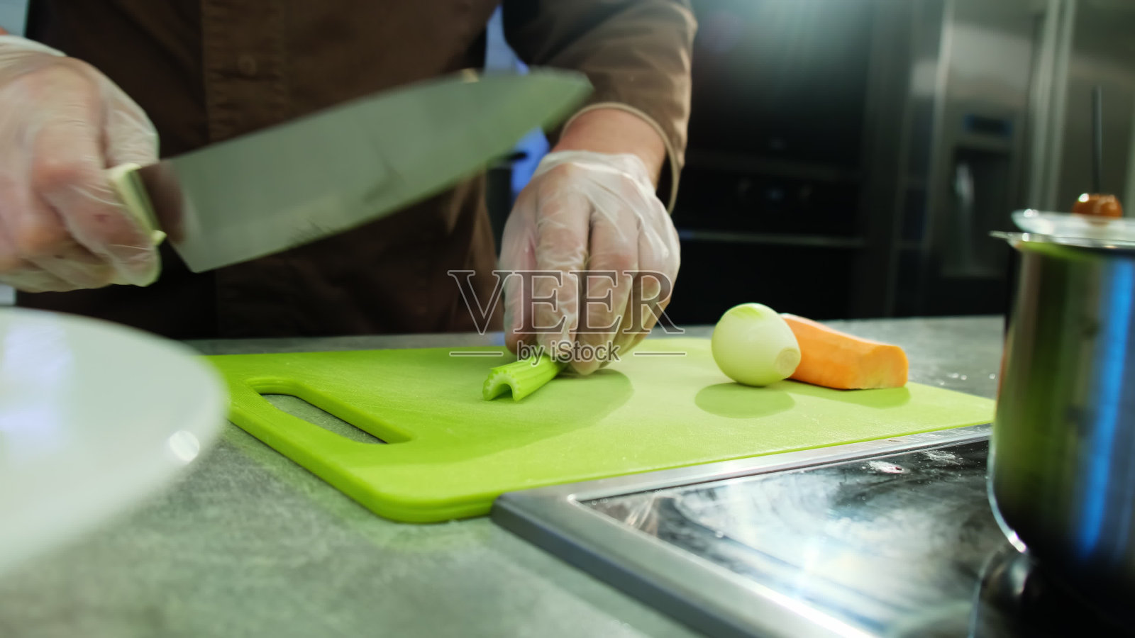 厨师用刀在菜板上切葱照片摄影图片