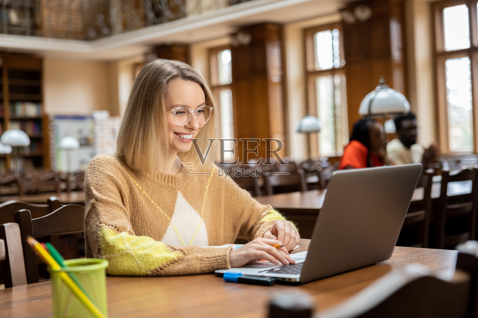 微笑的漂亮女人在图书馆工作照片摄影图片