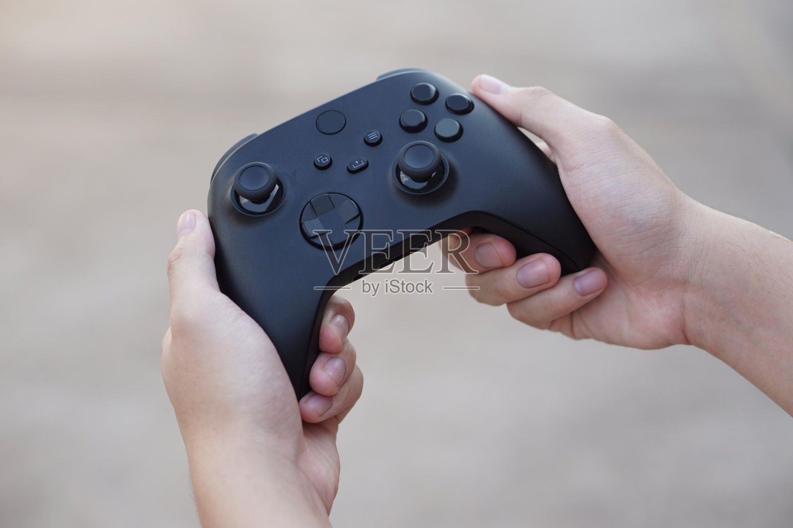 近距离手握黑色操纵杆或游戏控制器控制台。关于在线远程视频游戏到电脑屏幕娱乐的概念、技术设备。爱好、业余时间和娱乐活动。照片摄影图片