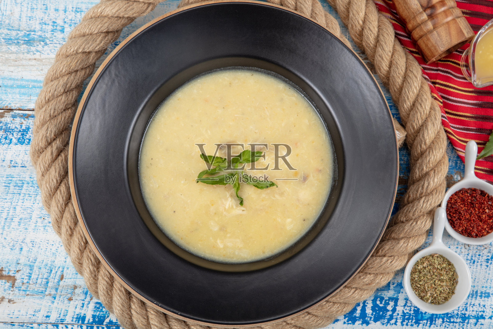 碗里的鱼汤。鱼汤与奶油，酱汁，柠檬，香草和面包丁木制背景。照片摄影图片