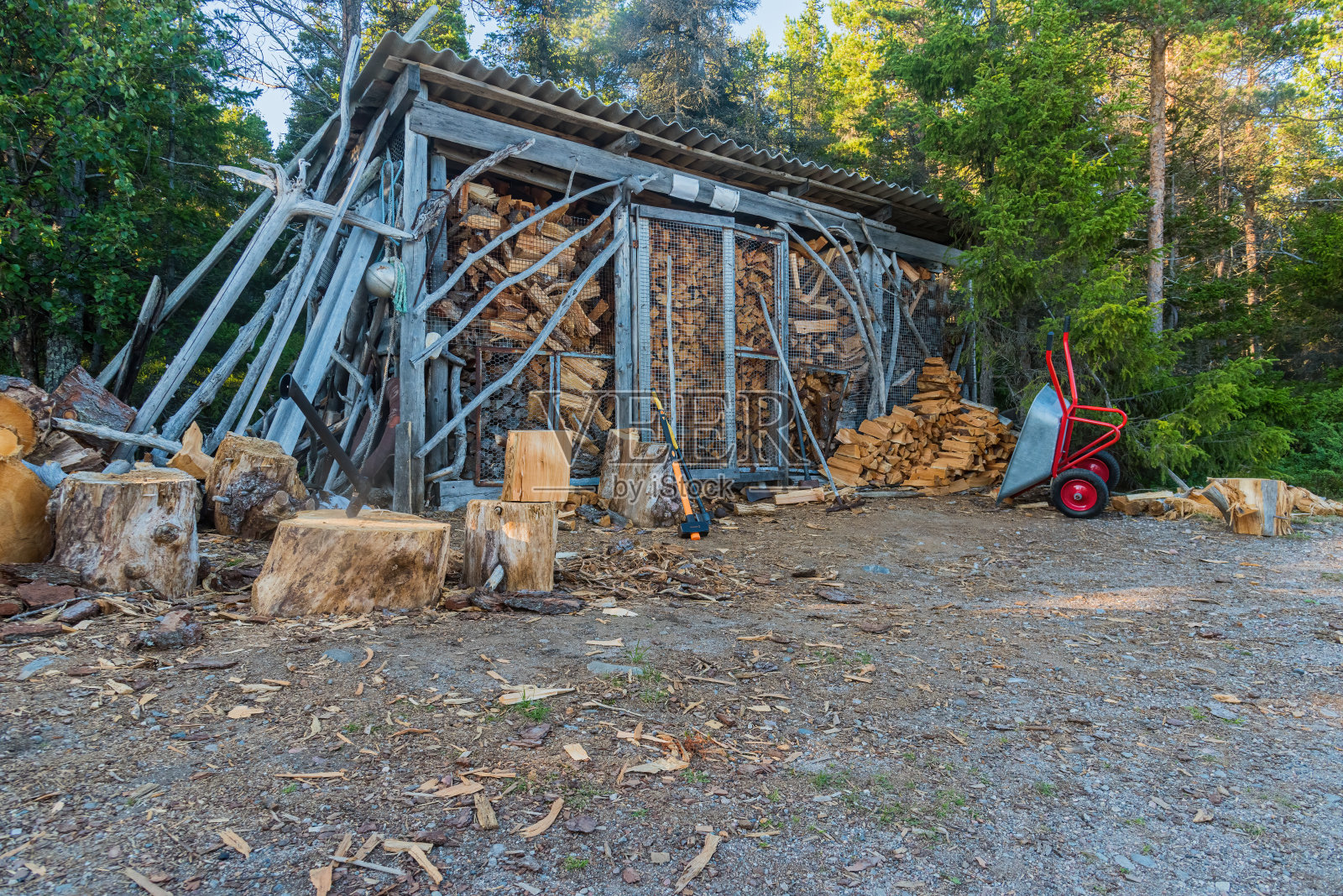 一把斧头和一把大锤，用来砍锯过的树，还有一个在森林里放木柴的棚屋。远离文明的生态村照片摄影图片