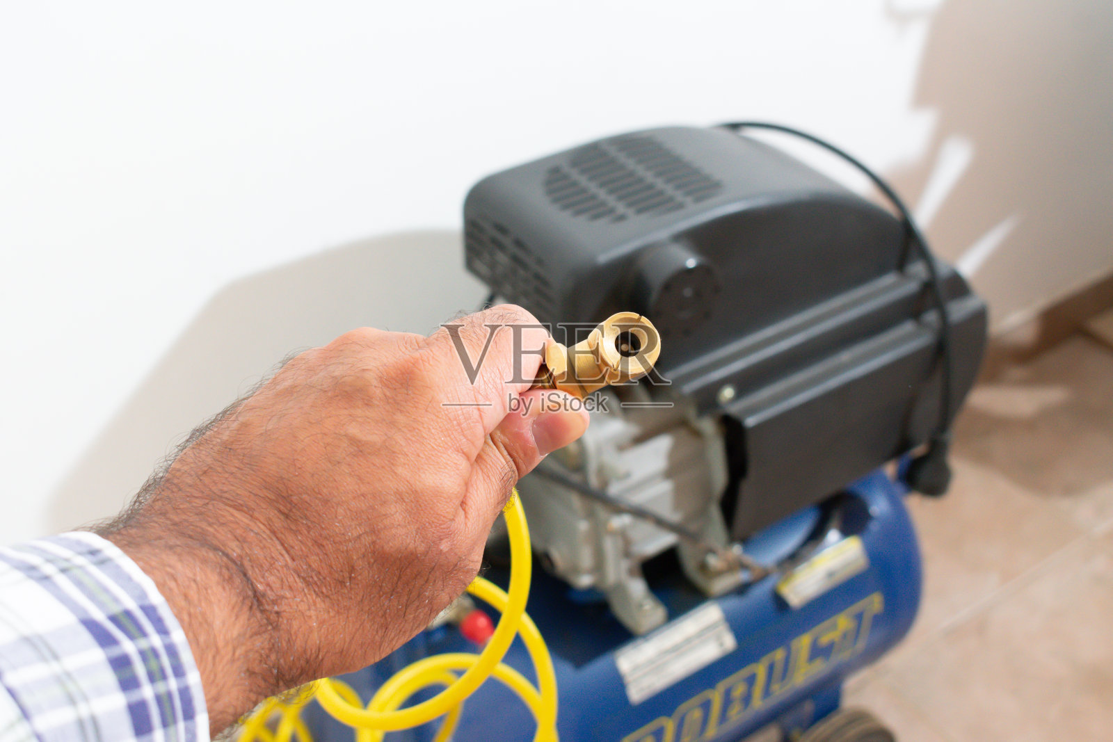 操作电动轮胎泵的操作员照片摄影图片