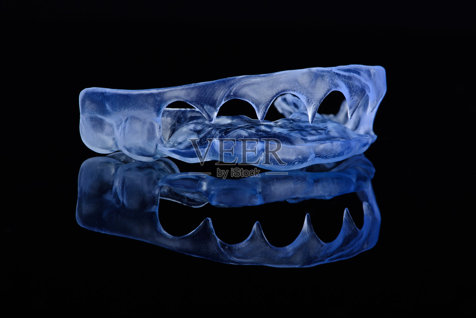 打印透明牙科帽由聚合物在浅色彩色背景。防止磨牙的牙夹板。照片摄影图片