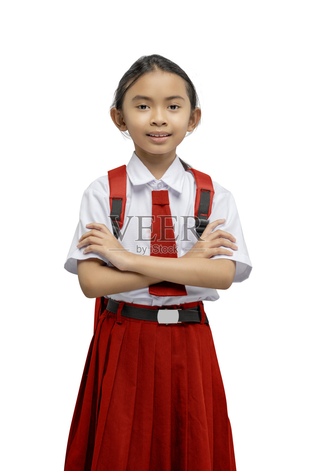 一个亚洲小学生的肖像，穿着制服，背着背包，双臂交叉站着照片摄影图片