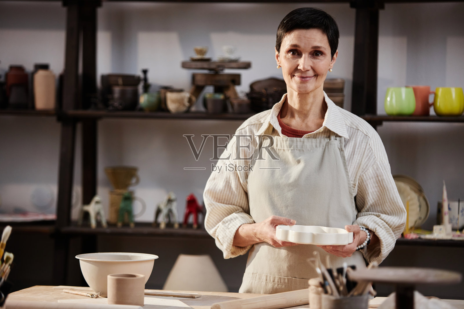 陶器作坊里的女工匠照片摄影图片