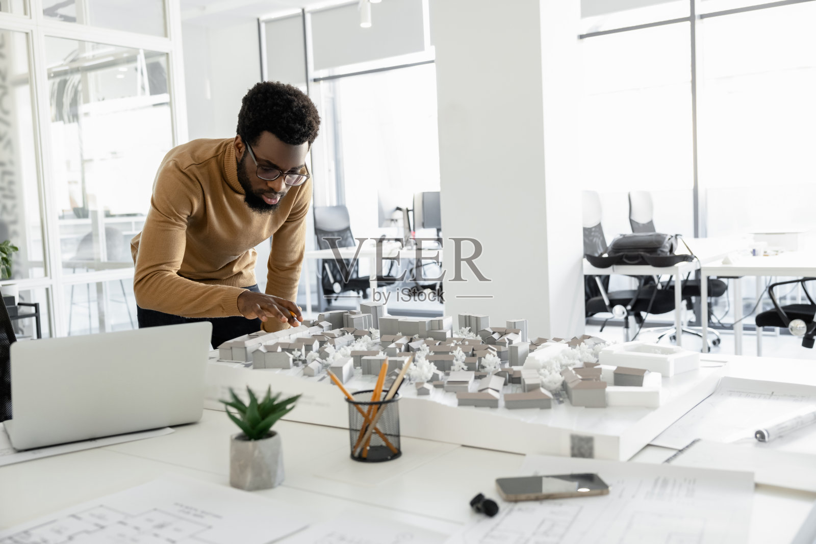 在办公室从事外部项目的熟练建筑师照片摄影图片