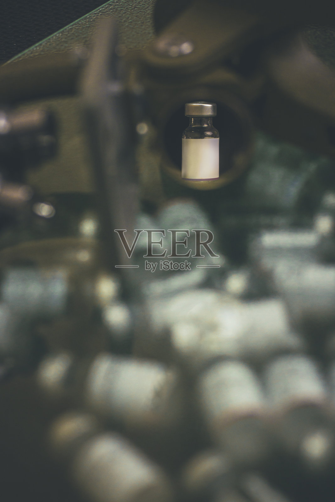 在一个小型科学实验室里，一台老式显微镜的玻璃上反射出一个微笑。照片摄影图片